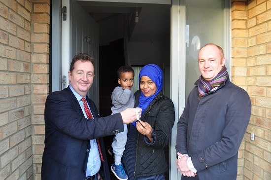 Councillor Julian Bell and Jamie Hunter from Hill present Khandra Khalif with the keys to her new house